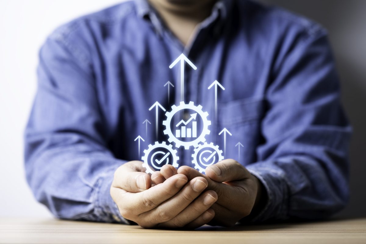 Businessman holding up arrow with mechanical gear and increasing graph for business improvement growth strategy on success development until achievement target and profit concept.