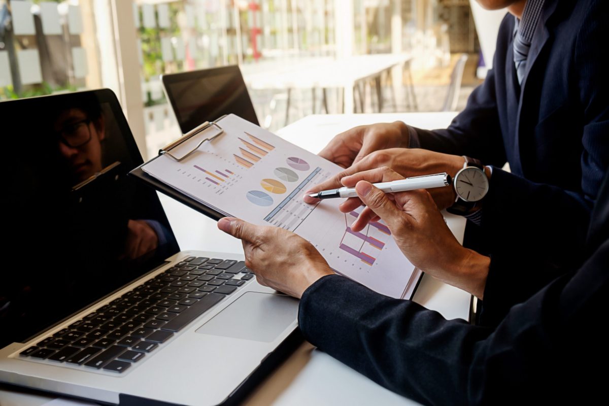 Business concept. Business people discussing the charts and graphs showing the results of their successful teamwork. Selective focus.