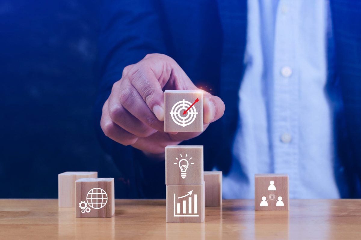 Hand arranging wood block stacking with business strategy and Action plan, targeting the business concept. Business development concept. Goal plan action.