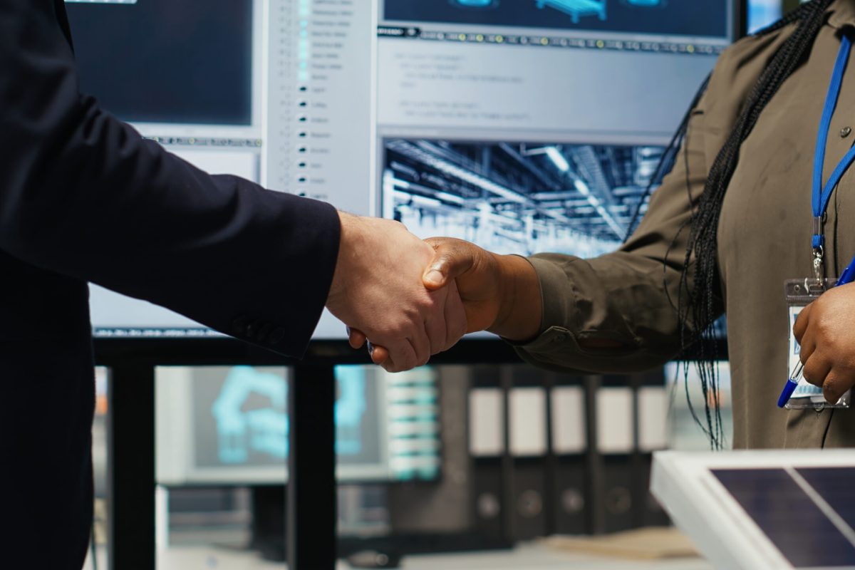 Investors shaking hands, closing deal after reviewing solar technology reports. Shareholders doing handshake, meeting to discuss investment opportunities in eco friendly energy production, camera B